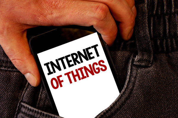Handwriting text Internet Of Things. Concept meaning Innovation Globalization Digital Electronics Connectivity Brown jeans back pocket hand pushing mobile phone with black and red text