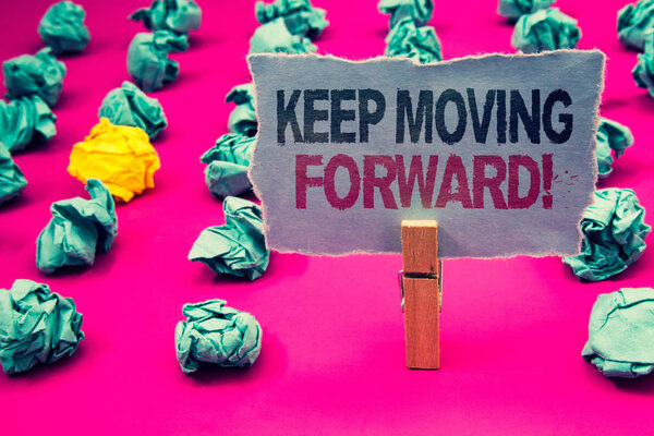 Writing note showing  Keep Moving Forward Motivational Call. Business photo showcasing Optimism Progress Persevere Move Emerald paper balls yellow lump rosy floor paperclip retain grey page