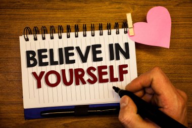 Conceptual hand writing showing Believe In Yourself. Business photo text Determination Positivity Courage Trust Faith Belief Human hand retain black pen notepad with words on paper pink heart clipart