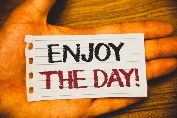 Handwriting text writing Enjoy The Day Motivational Call. Concept meaning Enjoyment Happy Lifestyle Relaxing Time Text two Words written white paper note hand open palm pencil message