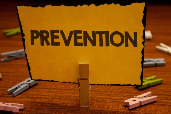 言葉を防止のテキストを書きます Protectionclothespin 保持洗濯はさみ木製の背景の黄色い紙のアイデアを保持起こってから何かを停止するためのビジネス コンセプト — ストック写真