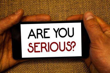 Kavramsal el are sen ciddi soru gösterilen yazma. İş fotoğraf metin var güvensizlik dalga cep telefonu ekran siyah kırmızı harflerle hasır arka planda tutan gerçek adamdır