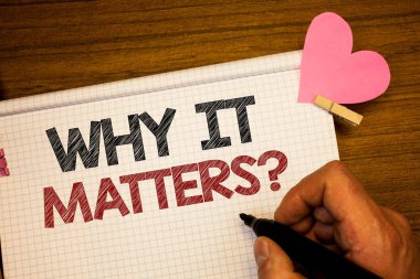 Neden bu konularda soru gösterilen Not yazma. Motivasyon gol kalem fikirler defter pembe kalp harf ahşap arka plan üzerinde tutan adam bir şey yapmak için önemli nedenler vitrine iş fotoğraf