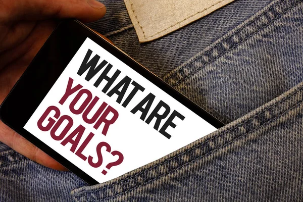 Writing note showing  What Are Your Goals Question. Business photo showcasing asking someone about his life targets Human hand bring out cell phone with colorful text jeans back pocket