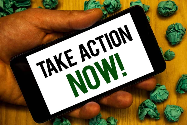 Handwriting text Take Action Now Motivational Call. Concept meaning Urgent Move Start Promptly Immediate Begin Hand holding phone white screen written words crumbled green notes paper