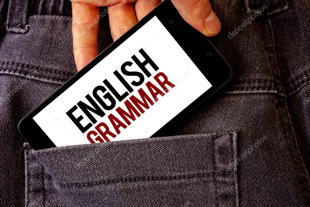 Conceptual hand writing showing English Grammar. Business photo showcasing Language Knowledge School Education Literature Reading Man holding cell phone white screen letters jeans pocket