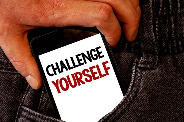 Handwriting text Challenge Yourself. Concept meaning Overcome Confidence Strong Encouragement Improvement Dare Brown jeans back pocket hand pushing mobile phone with black and red text