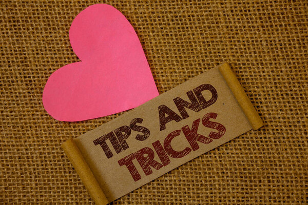 Handwriting text Tips And Tricks. Concept meaning Suggestions to Make things easier Helpful Advices Solutions Ideas on old vintage paper black red letters wicker background pink heart