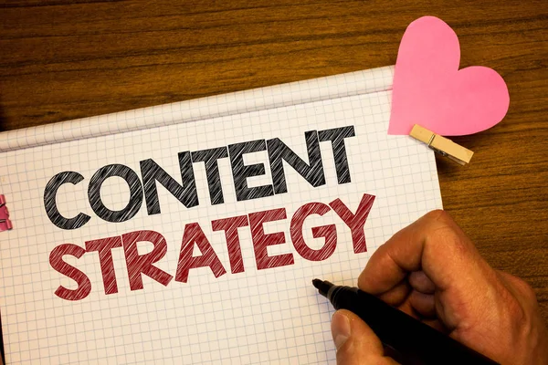 İçerik stratejisi gösterilen Not yazma. İş fotoğraf yönetimi ağ Internet Web sitesi pazarlama planı kalem fikirler defter pembe kalp harf ahşap arka plan üzerinde tutan adamı vitrine