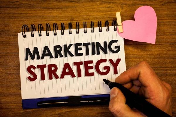 概念性手写显示营销策略 商务照片文本计划公式创意研究组织人手在纸粉红色的心脏保留黑笔记事本与词 — 图库照片