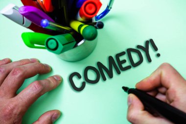 Komedi ara gösterilen metin işareti. Kavramsal fotoğraf eğlenceli mizah hiciv Sitcom neşe şaka eğlence gülen siyah kalemi beyaz arka plan işaretleri niyeti tutan adam iletişim