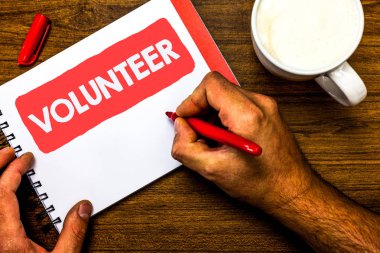 Gösterilen metin işaret gönüllü. Kavramsal fotoğraf gönüllülük birey daha büyük sosyal neden diğer Kupası işareti kırmızı kalem Not defteri beyaz kağıt güzel fikirler hizmet için sanat eser ahşap sanıyordum