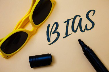 Writing note showing  Bias. Business photo showcasing Unfair Subjective One-sidedness Preconception Inequality Bigotry Ideas messages beige background black marker markers yellow sunglasses clipart