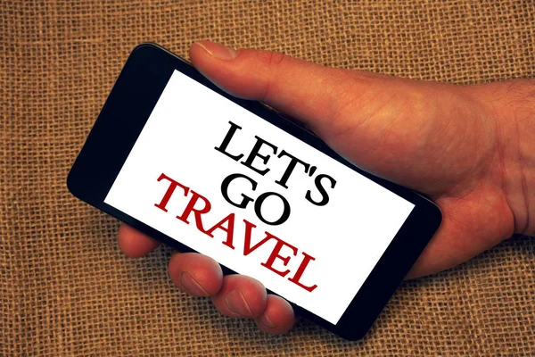Word writing text Let'S Go Travel. Business concept for Going away Travelling Asking someone to go outside Trip Owner hold holding smartphone white screen message application intention