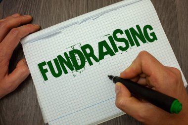 Conceptual hand writing showing Fundraising. Business photo text Seeking of financial support for charity cause or enterprise Man hold holding black marker gruge notebook wooden wood table clipart
