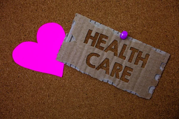 Conceptual hand writing showing Health Care. Business photo text Medical Maintenance Improvement of Physical Mental conditions Brown old damaged paperboard ideas pink heart cork background