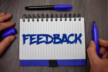 Word metin yazma geribildirim. İş kavramı müşteri gözden geçirme görüş tepki değerlendirme vermek için bir yanıt geri adam tutun ahşap arka plan mavi işaretleyiciyi defter sayfası kağıt fikirleri holding