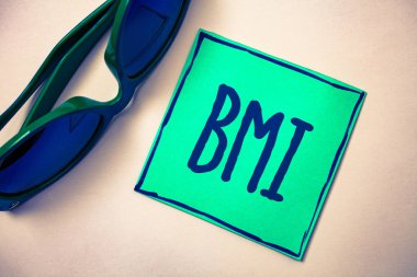 Word metin yazma BMI. Vücut kitle indeksi için iş kavramı yükseklik yeşil kağıt bej arka plan güneş gözlüğü fikirler mesajlar duyguları düşünceleri ile ilgili sağlıklı kilo aralığı belirler