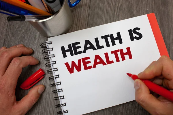 Handwriting text Health Is Wealth. Concept meaning being in good shape great value Stay healthy eat Healthy Notepad pen information ideas message thoughts invite wooden background