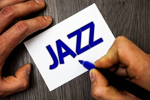 Conceptual hand writing showing Jazz. Business photo showcasing Type of music of black American origin Musical genre Strong rhythm Man working holding blue marker ideas paper wooden table