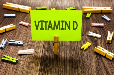 Vitamin d iş gösterilen Not yazma vitrine faydaları sunbeam pozlama fotoğraf ve bazı yağ çözünen vitaminlerinin klip sanat kurulu yaratıcı fikirler ataç ahşap gölge holding kağıt