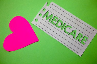 Kavramsal el Medicare gösterilen yazma. Kişilerin yukarıda 65 veya Engelli küçük kağıt çizim kalp yeşil arka plana sahip federal sağlık sigortası vitrine iş fotoğraf hatırlıyorum mesaj