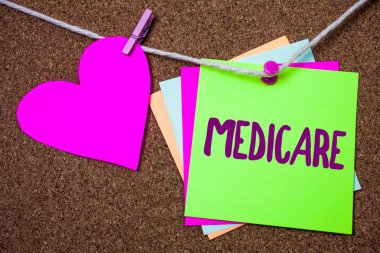 Word metin yazma Medicare. İş kavramı kişilerin yukarıda 65 veya Engelli kalp iplik yapışkan küçük cliped dize başparmak PIN koyu kaba arka plan ile Federal sağlık sigortası için