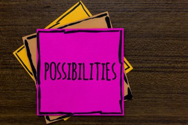Writing note showing Possibilities. Business photo showcasing Things that may happen or be the case State of being possible Three art small paper two yellow one pink wood brown lite grey shadow clipart
