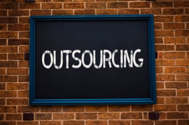 Kavramsal el dış kaynak gösterilen yazma. İş sözleşmesi bir dış tedarikçi çerçeveli asmak kara tahta çalışma sınıf tuğla duvar arka plan ile vitrine elde edilir malın veya hizmetin fotoğraf