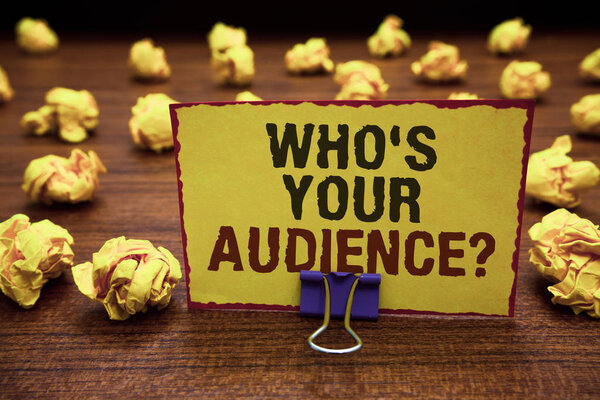 Handwriting text writing Who s is Your Audience question. Concept meaning asking someone about listeners category Coaching Yellow sticky card clipped text notice crumpled paper balls wood table