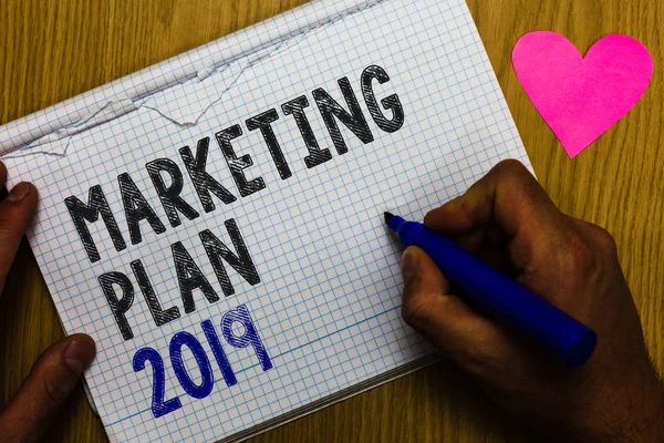 Handwriting text Marketing Plan 2019. Concept meaning schedule defining brand selling way in next year Paper register multiline text pen handwriting love heart table background
