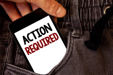 Text sign showing Action Required. Conceptual photo Important Act Needed Immediate Quick Important Task Text two words on white screen black Phone Hand holding grey jeans pocket clipart