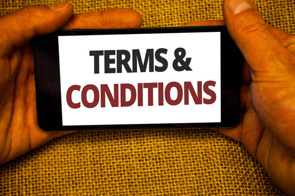 Text sign showing Terms  and Conditions. Conceptual photo Legal Law Agreement Disclaimer Restrictions Settlement Jute sack background hand holding iPhone with colorful alphabetic syllable