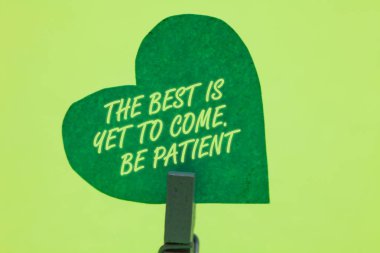 Kavramsal el en iyi olduğunu henüz gelmek gösterilen yazma. Sabırlı ol. İş fotoğraf vitrine kaybetme umut ışık gel karanlığa sonra Clothespin holding yeşil kağıt kalp romantik mesaj fikirler