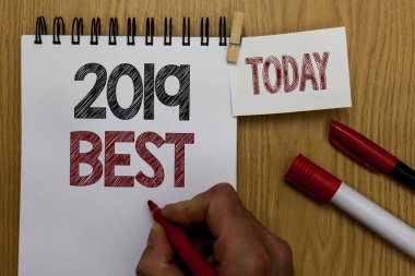 Conceptual hand writing showing 2019 Best. Business photo text Highest quality done in all fields preparing for the next year Man holding marker notebook wooden table for today coffee cup clipart
