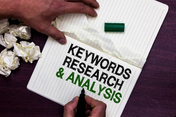 Text sign showing Keywords Research and Analysis. Conceptual photo search for data and create tables graphs Man holding marker notebook page crumpled papers several tries mistakes