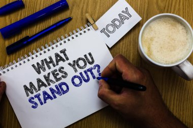 Ne gösterilen metin işareti soru dışarı Stand yapar. Kavramsal fotoğraf biri defter clothespin hatırlatma ahşap masa fincan kahve onun nitelikleri adam holding işaretleyici hakkında soran