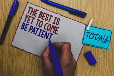 Conceptual hand writing showing The Best Is Yet To Come. Be Patient. Business photo text dont lose hope light come after darkness Man holding marker paper clothespin express ideas wooden table clipart