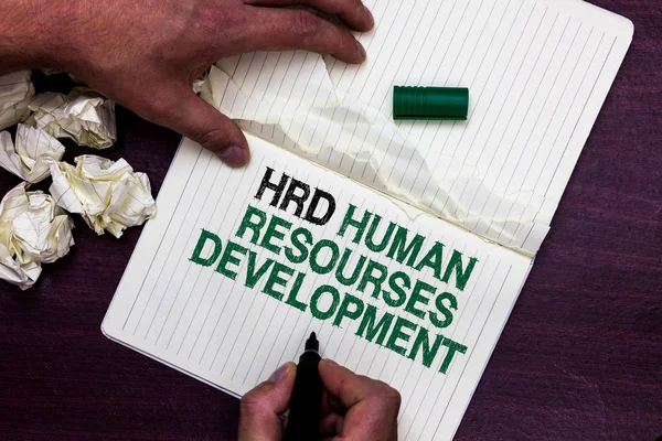 Text sign showing Hrd Human Resources Development. Conceptual photo helping employees develop personal skills Man holding marker notebook page crumpled papers several tries mistakes