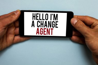 Word writing text Hello I am A Change Agent. Business concept for Promoting and enabling difference evolution new Human hand hold smartphone with red and black letters on shadow blue floor clipart