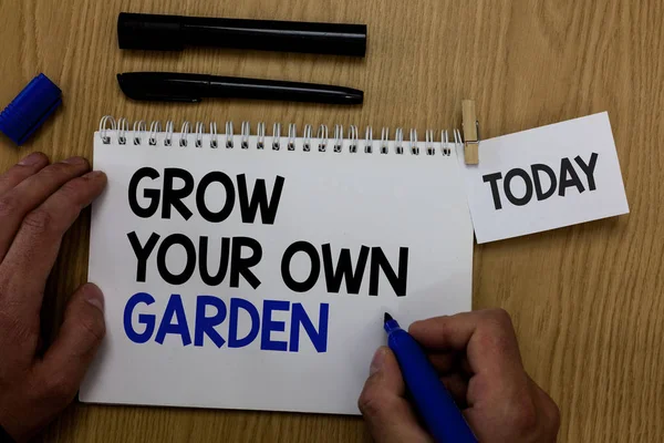Word writing text Grow Your Own Garden. Business concept for Organic Gardening collect personal vegetables fruits Hand hold pen notepad with words paperclip grip note paper woody base black pen