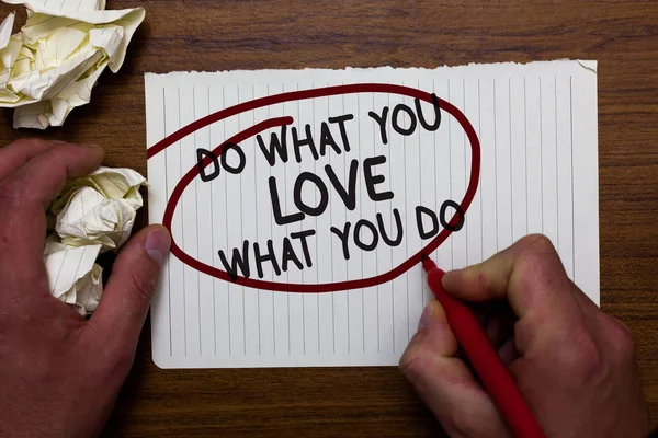 Text sign showing Do What You Love What You Do. Conceptual photo Make things that motivate yourself Passion Hand hold paper lob and red pen red circled black words on white paper