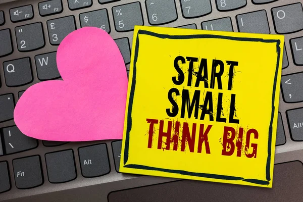 Handwriting text writing Start Small Think Big. Concept meaning Initiate with few things have something great in mind Written on black bordered yellow page touched pink heart on computer keyboard