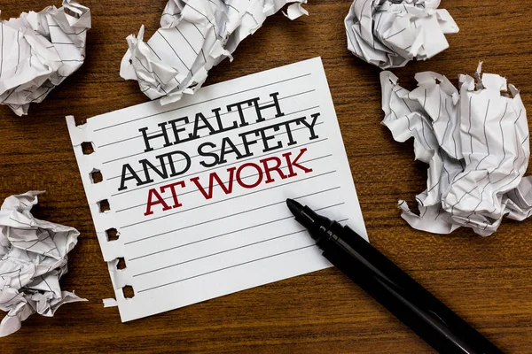 Text sign showing Health And Safety At Work. Conceptual photo Secure procedures prevent accidents avoid danger Paper lumps laid randomly around white notepad touch black pen on woody floor