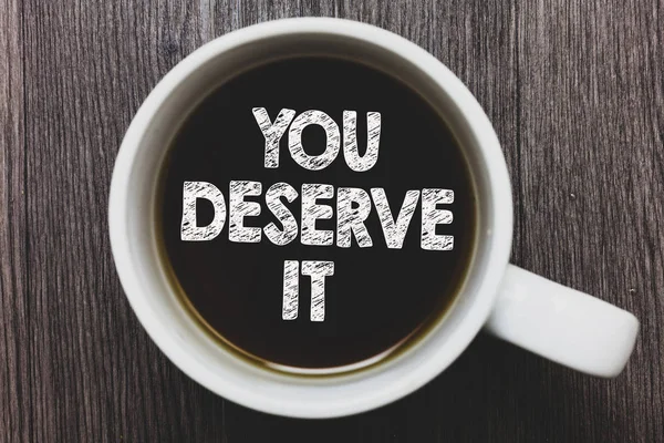 Word writing text You Deserve It. Business concept for Reward for something well done Deserve Recognition award Black coffee with coffee mug floating texts on gray black wooden desk