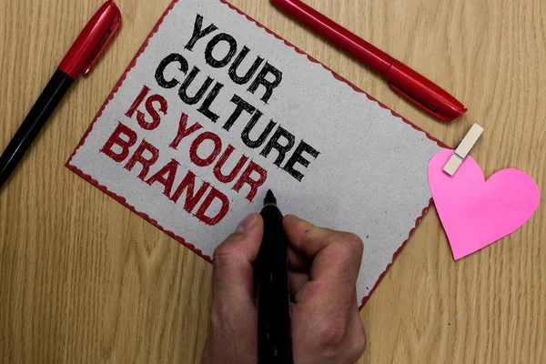 Text sign showing Your Culture Is Your Brand. Conceptual photo Knowledge Experiences are a presentation card Written sticky note clip pinch heart hand hold marker red pen on wooden desk