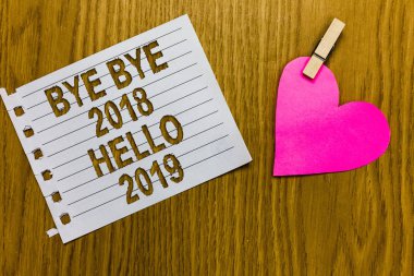 Kavramsal el güle güle güle güle 2018 yılına Merhaba 2019 gösterilen yazma. Sarı odunsu güverte word beyaz sayfa ataş kavrama kalp ile iş fotoğraf vitrine başlangıç yeni yıl motivasyon mesajı 2018 bitti