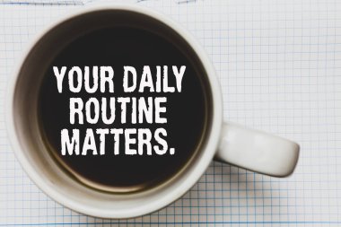 Writing note showing Your Daily Routine Matters. Business photo showcasing Have good habits to live a healthy life Coffee mug with black coffee floating some white texts on white paper clipart