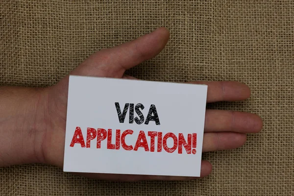 Writing note showing Visa Application. Business photo showcasing Form to ask permission travel or live in another country Human hand holding white page with black and red color texts on sack