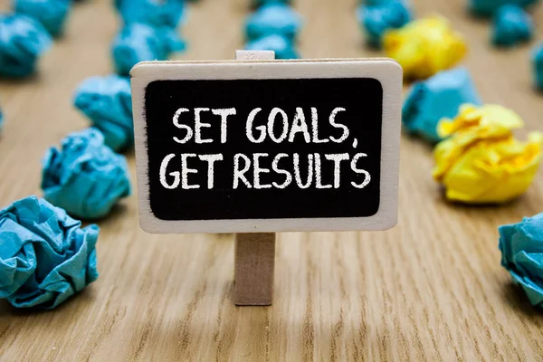 Text sign showing Set Goals, Get Results. Conceptual photo Establish objectives work for accomplish them Paperclip hold written chalkboard behind paper lumps on woody deck